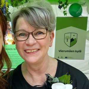 Lyhythiuksinen nainen hymyilemässä.